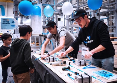 Collaborateurs en train de présenter à des enfants un atelier sur le thème de la puissance de l'air à l'occasion de l'inauguration des nouveaux bâtiments de la société Palamatic Process.