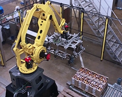 Robot palettiseur en train de mettre des barquettes sur une palette en automatique